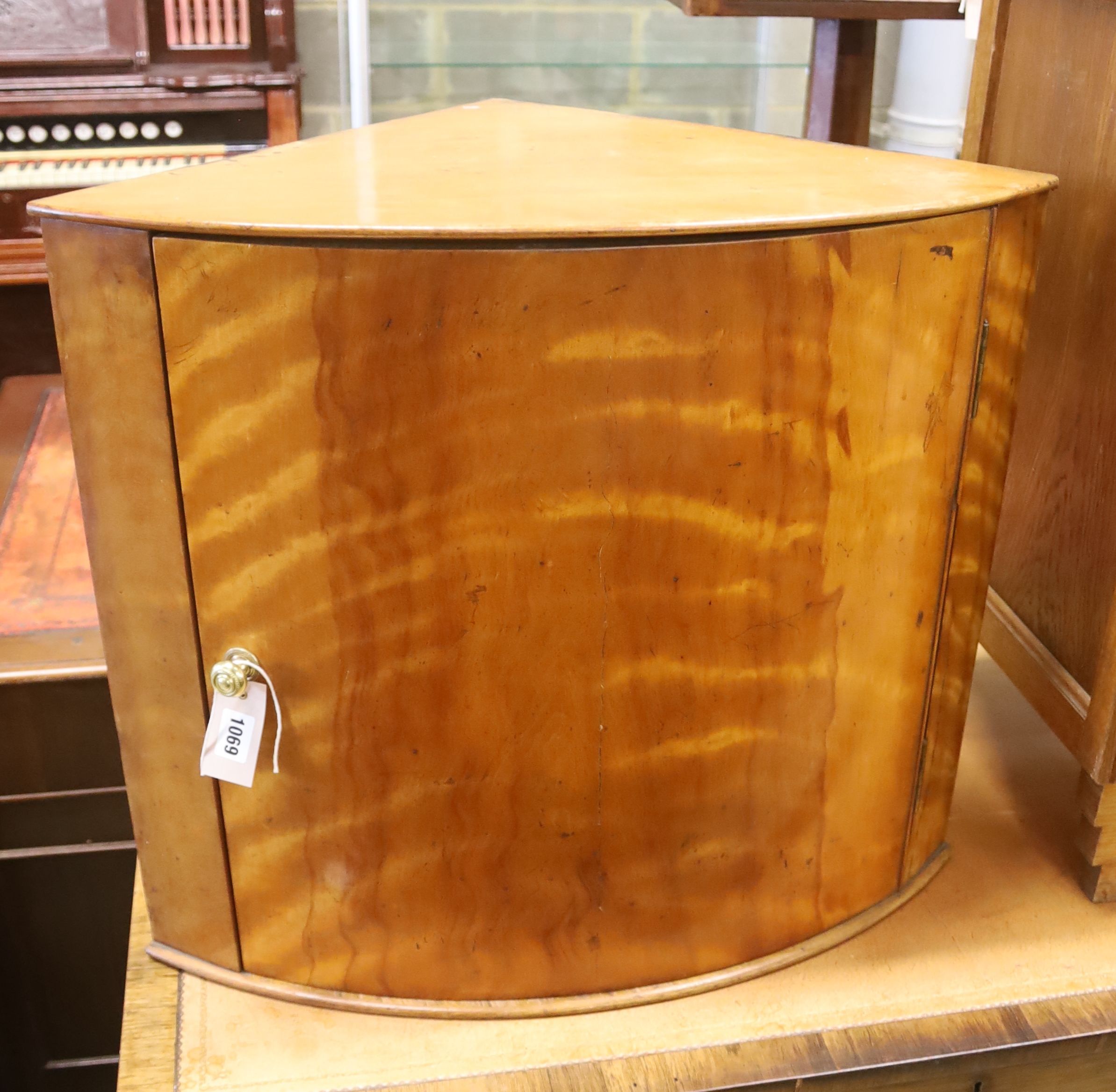 A Victorian satin birch bow front hanging corner cabinet, width 64cm, depth 43cm, height 56cm